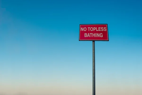 No topless bathing red sign in front of blue sky — Stock Photo, Image