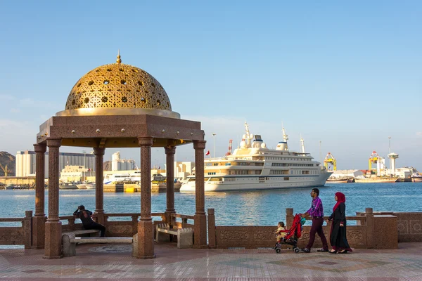 Onbekende jonge gezin lopen naar het monument voor muscat haven — Stockfoto