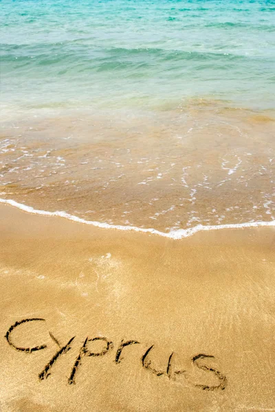 Cipro scritto in sabbia sulla spiaggia con il mare sullo sfondo — Foto Stock
