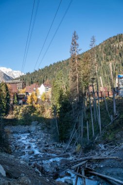 Bir sonbahar günü, yüksek karlı dağların arasında küçük bir turist köyünde yürümek.
