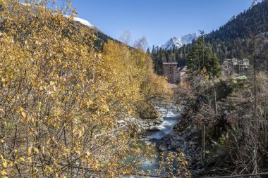 Bir sonbahar günü, yüksek karlı dağların arasında küçük bir turist köyünde yürümek.