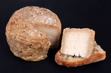 Korsika koyun peyniri ve siyah arka planda bir parça ekmek.