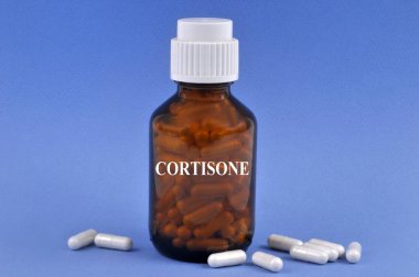 Mavi arka planda şişe ve kapsüllerle kortizon kavramı