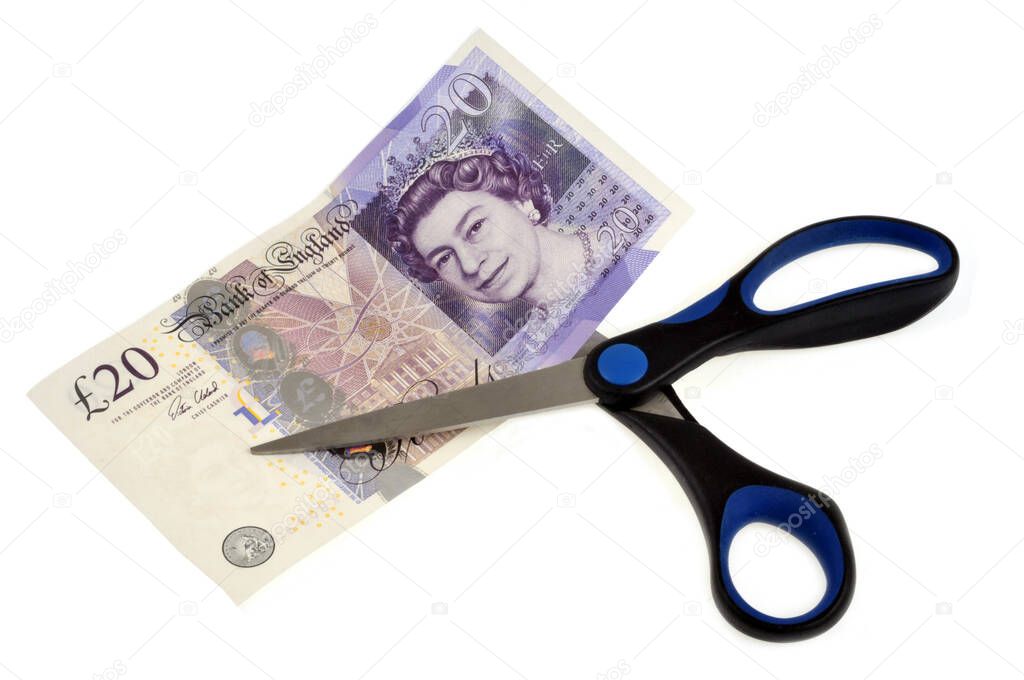 Billete de banco de veinte libras esterlinas cortado con tijeras de