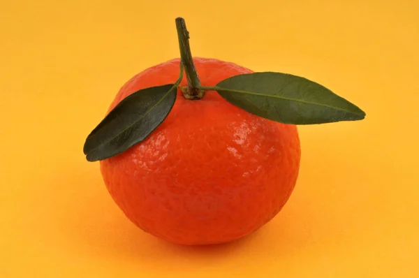 Tangerine Dengan Daun Close Pada Latar Belakang Kuning — Stok Foto