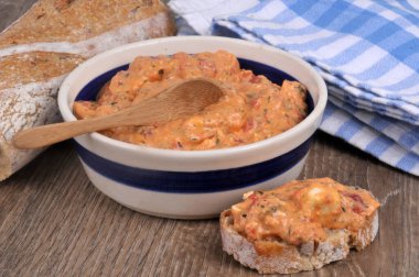 Ktipiti bir kepçenin içinde, tahta kaşıkla yakın plan bir ekmeğin yanında.