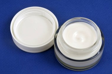 Mavi arkaplanda yakın plan nemlendirici kavanozu açıldı 