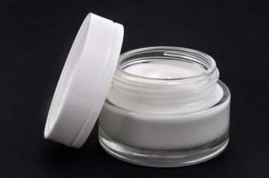 Siyah arkaplan üzerine yakın plan nemlendirici kavanozu aç 