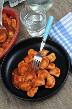 Mantı tabağı, çatalla servis edilir. Yanında da mantı ve bir bardak su manzarası. 