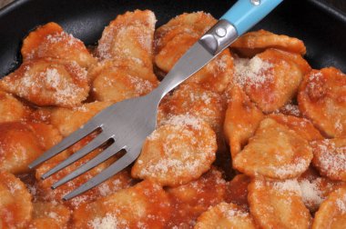 Domates soslu Ravioli, parmesan peyniri ve yakın plan çatal.