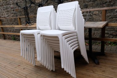 Bir bar terasında beyaz plastik sandalyeler 