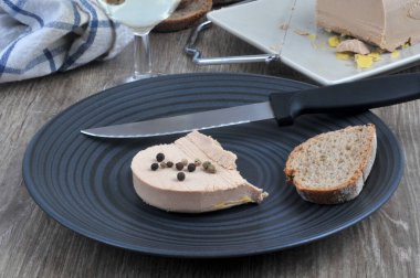 Meyveli kaz ciğeri ve tabakta bir dilim ekmek.