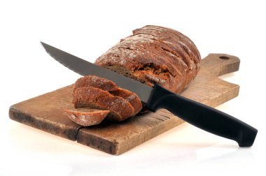 Dilimlenmiş çavdar ekmeği ve beyaz bir arka planda kesme tahtasının üzerinde bıçak. 