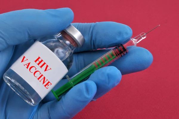 Hivワクチンのコンセプトバイアルと注射器でラテックス手袋を手に赤の背景 — ストック写真