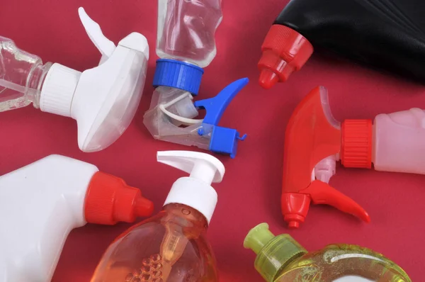 Various sprays and household products close-up on red background