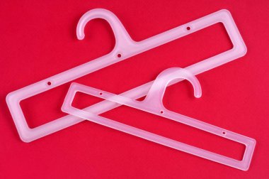 Plastic hangers close-up on red background 