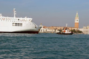 Venedik gölünde bir römorkör tarafından çekilen bir okyanus gemisi