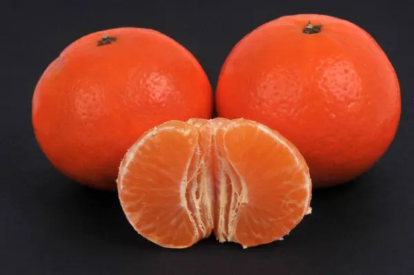 Ganze Mandarinen Und Geschälte Mandarinen Nahaufnahme Auf Schwarzem Hintergrund — Stockfoto