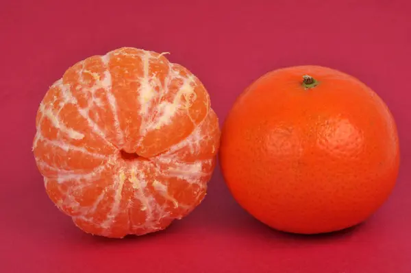 Mandarina Entera Mandarina Pelada Cerca Sobre Fondo Rojo — Foto de Stock