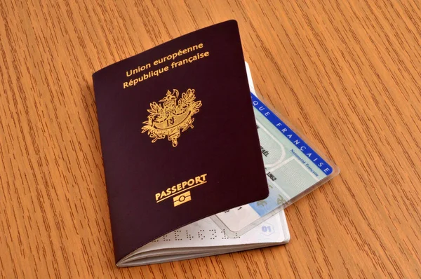 Tahta bir masanın üzerinde kimlik kartı olan Fransız biyometrik pasaportu. 