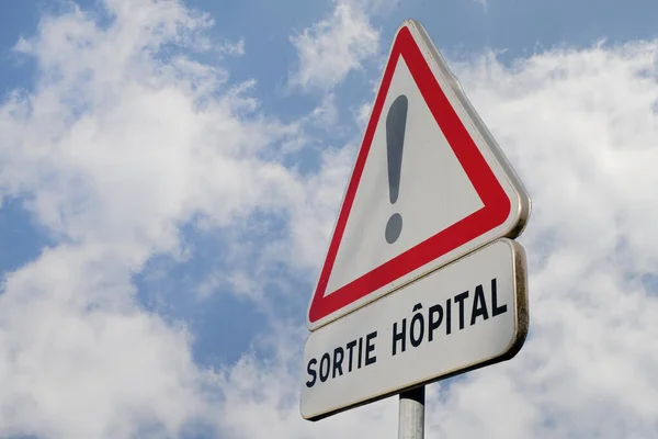 曇り空の病院からの退院を示すフランスの道路標識 — ストック写真