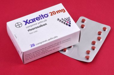 Rivaroxaban kutusu kırmızı arka planda bir paket uyuşturucuyla 
