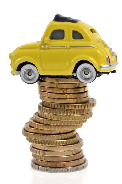 Transportation budget concept with toy car on stack of coins on white background 