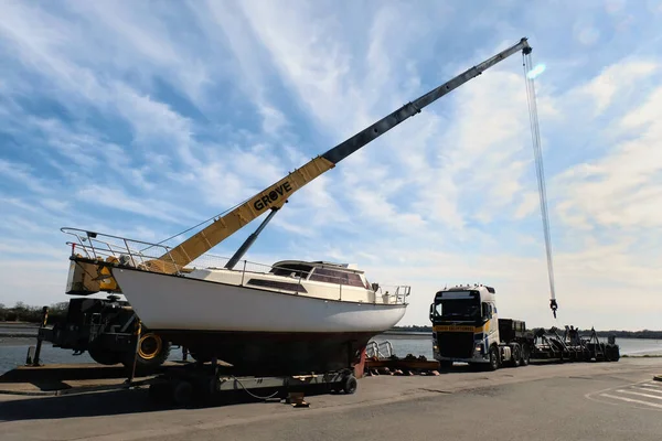 Vannes Limanı 'nda vinç kamyonu ve yarı römorklu bir yelkenli resepsiyonu.