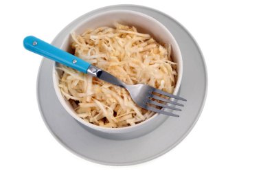 Beyaz arka planda çatallı rendelenmiş kereviz kasesi.