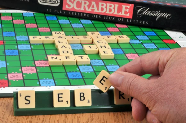 Mão Segurando Uma Carta Scrabble Para Fazer Uma Palavra Francês — Fotografia de Stock