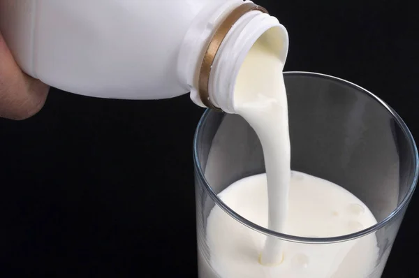 Verter Leche Vaso Primer Plano Sobre Fondo Negro — Foto de Stock