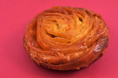 Kırmızı arkaplanda Kouign-amann yakın plan 