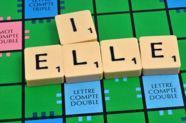 Erkek ve kadının Scrabble oynadığı zamirleri oluşturan mektuplar 