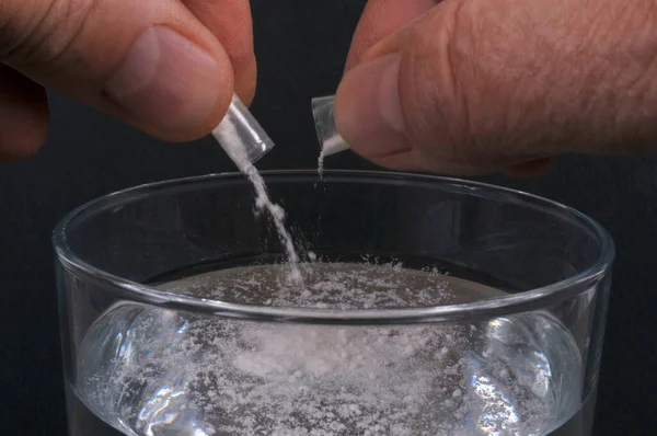 Concept of pouring GHB into a glass with powder from a capsule