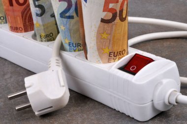 Gri arka planda elektrik uzatma kablosu ve avro banknotlarıyla elektrik giderleri kavramı