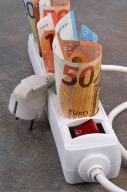 Gri arka planda elektrik uzatma kablosu ve avro banknotlarıyla elektrik giderleri kavramı 