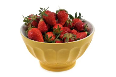 Bir kase çilek beyaz arka plana kapanıyor.