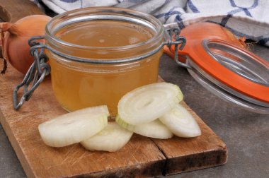 Kavanoz dolusu beyaz soğan suyu ve içindekiler yakın plan kesim tahtasında.