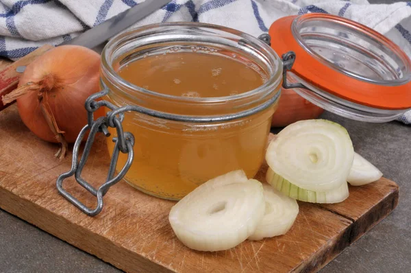 Kavanoz dolusu beyaz soğan suyu ve içindekiler yakın plan kesim tahtasında.