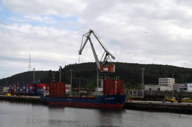 Kargo, Aviles Limanı 'nın yükleme rıhtımında bir liman vinci ile birlikte. 