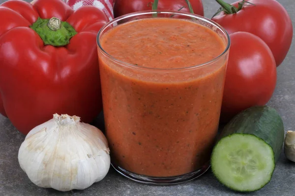 stock image Glass of homemade gazpacho with its ingredients close-up 