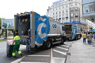 İspanya, La Coruna 'da bir sokakta çöp kamyonları ve çöp toplayıcıları