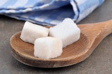 Tahta kaşıkta şeker küpleri yakın plan.