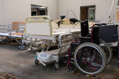 Kullanımdan kaldırılmış hastane yatakları ve tekerlekli sandalyeler.