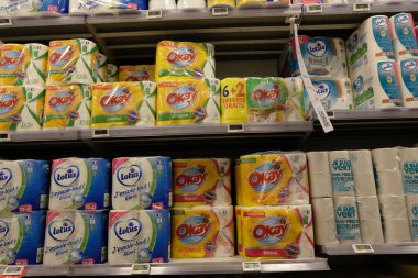 Packets of toilet paper and paper towels on the shelf in a supermarket