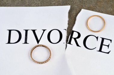 Divorce concept with torn sheet of paper and wedding rings 