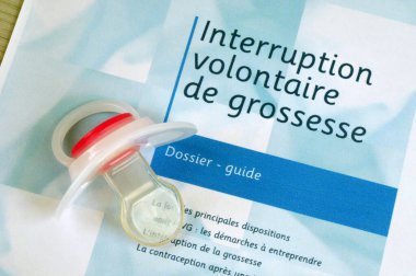 French guidebook on voluntary termination of pregnancy with a pacifier placed on it