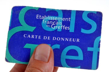 French organ donor card in hand close up on white background 
