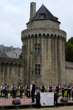 Vannes, France, August 15, 2022 : Musicians from a Breton bagad at the Arvor festival in Vannes in Brittany with the Connetable tower in the background