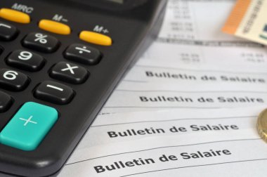 French salary slips with euros and a calculator